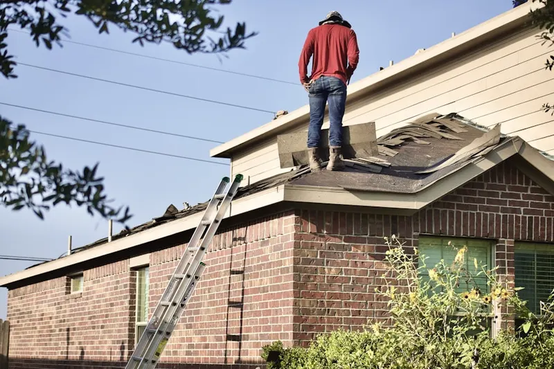 Professional roofer working on a residential roof in Foxboro